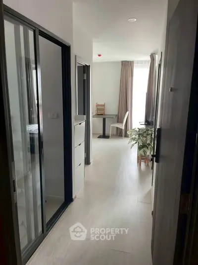 Modern apartment hallway leading to a bright living area with stylish decor.