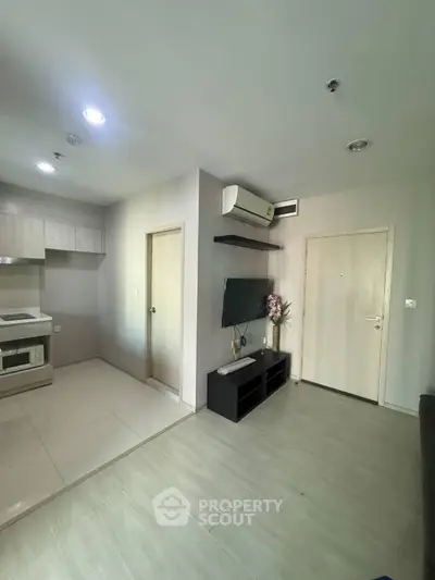 Modern apartment interior with open kitchen and living area, featuring sleek design and neutral tones.