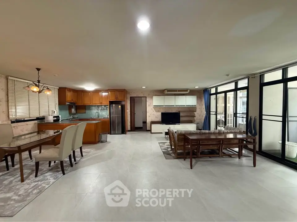 Spacious open-plan living and dining area with modern kitchen and large windows.