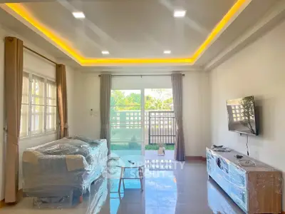 Spacious living room with modern lighting and garden view, perfect for relaxation and entertainment.