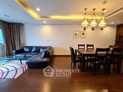 Spacious living room with elegant dining area and cozy leather sofa, featuring modern lighting and wooden flooring.