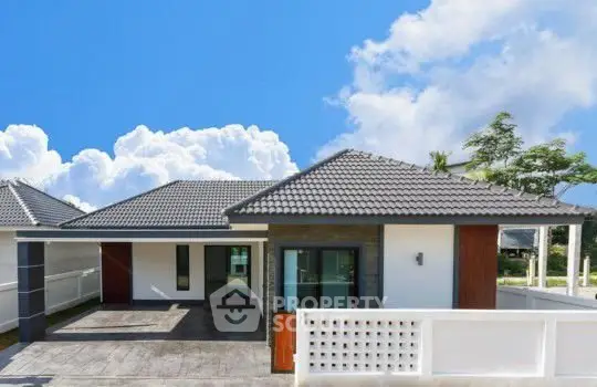 Modern single-story house with tiled roof and spacious driveway under a clear blue sky.