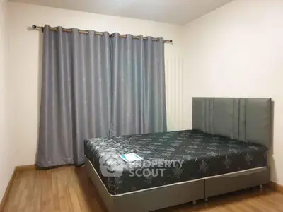 Spacious bedroom with elegant curtains and modern bed frame, perfect for a cozy retreat.