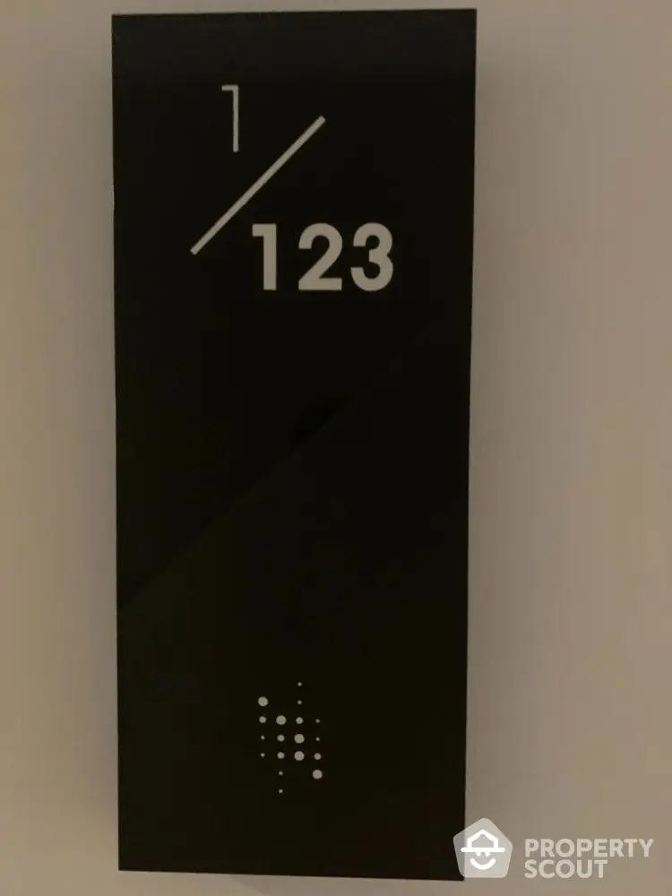 Modern apartment number sign with sleek black design and white numerals