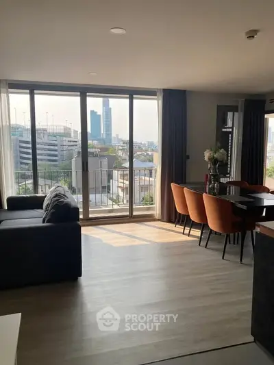 Modern living room with large windows and city view, featuring stylish dining area and cozy seating.