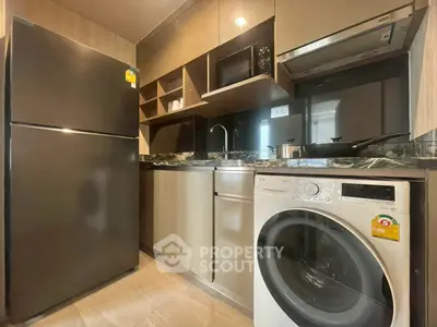 Modern kitchen with sleek appliances and washer in compact layout