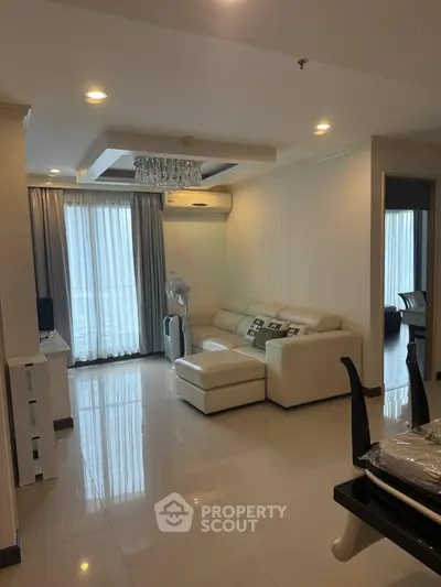 Spacious modern living room with elegant white sofa and large windows for natural light.