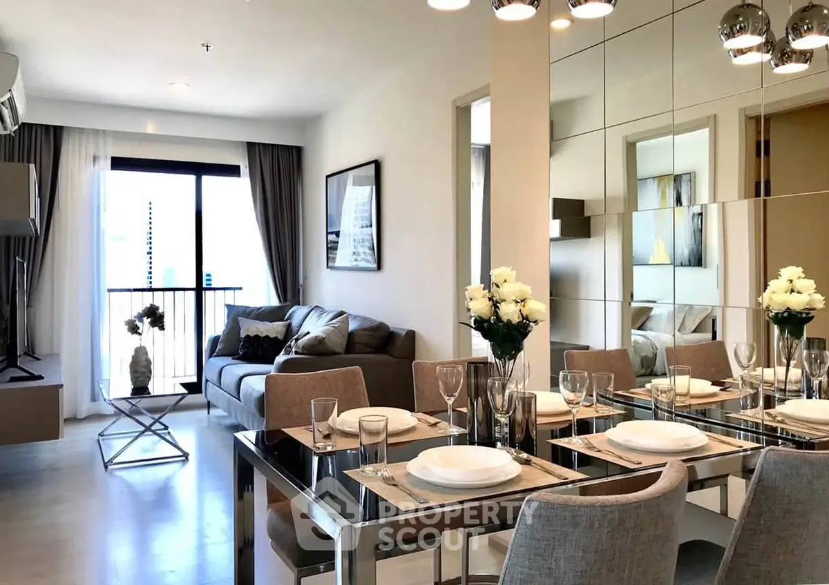 Modern living and dining area with elegant decor and natural light in a stylish apartment.