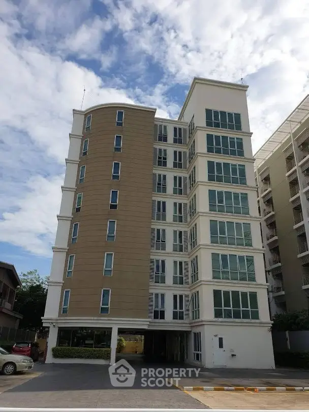 Modern multi-story residential building with sleek design and ample windows under a clear blue sky.