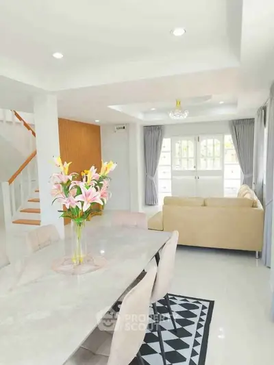 Bright and spacious living room with modern decor and elegant dining area, perfect for family gatherings.
