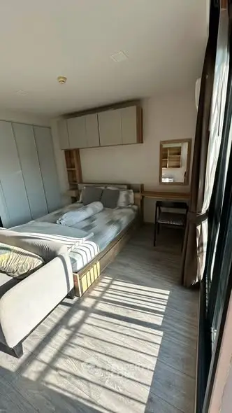 Modern bedroom with natural light, stylish furniture, and cozy ambiance in a contemporary apartment.