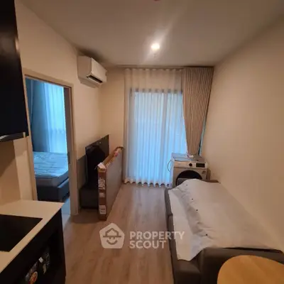 Cozy living room with modern furnishings and natural light, featuring a compact layout and stylish decor.