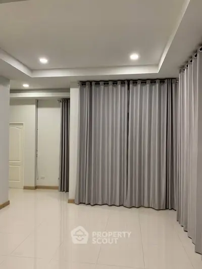 Spacious empty room with elegant curtains and modern lighting