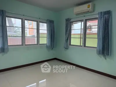 Bright room with large windows and air conditioning, ideal for a cozy living space.