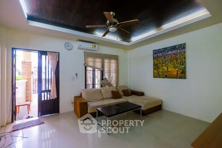 Spacious living room with modern ceiling fan and cozy sofa
