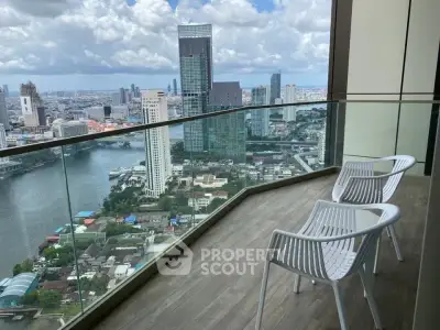Stunning high-rise balcony with panoramic city and river views, featuring modern seating for relaxation.