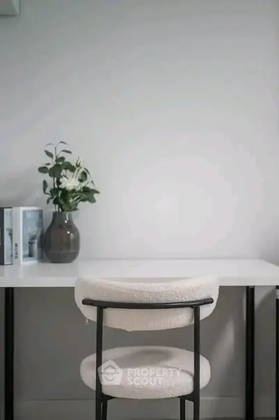 Minimalist study area with modern chair and decorative plant on desk
