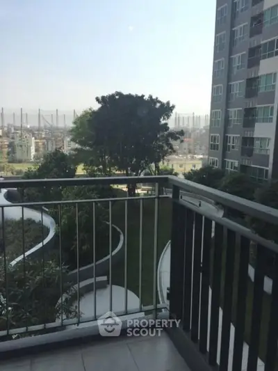Modern apartment balcony with city view and lush greenery, perfect for urban living.