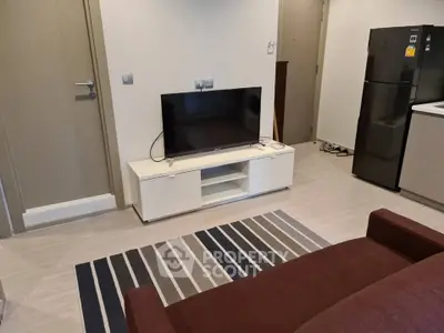 Modern living room with sleek TV setup and stylish kitchen area