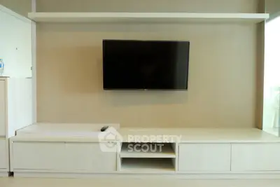 Modern living room with sleek TV unit and mounted flat-screen television.