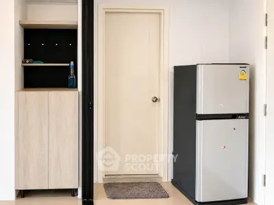 Modern apartment interior with sleek fridge and storage cabinet