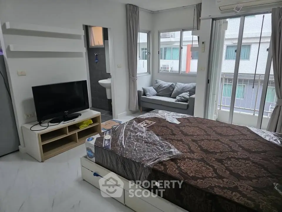 Modern studio apartment with cozy bed and natural light