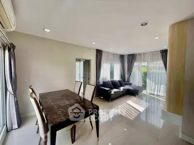 Spacious living room with elegant dining area and large windows