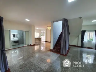 Spacious living area with polished marble floors, elegant staircase, and ample natural light, perfect for luxurious family living and entertaining.