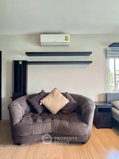 Cozy living room with plush sofa and modern air conditioning unit