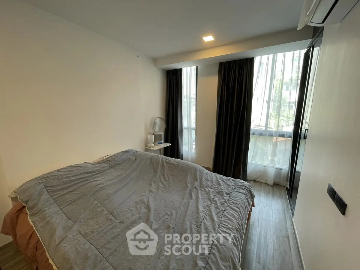 Cozy bedroom with large window and modern decor in urban apartment