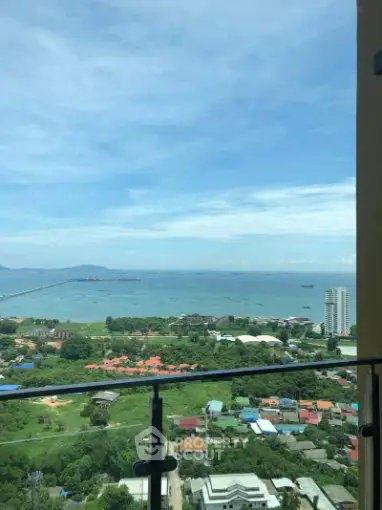 Stunning high-rise balcony view overlooking ocean and lush greenery.