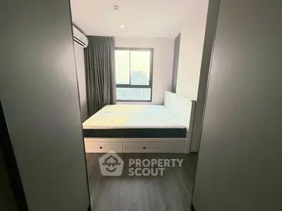 Modern bedroom with large window and city view, featuring sleek design and ample natural light.