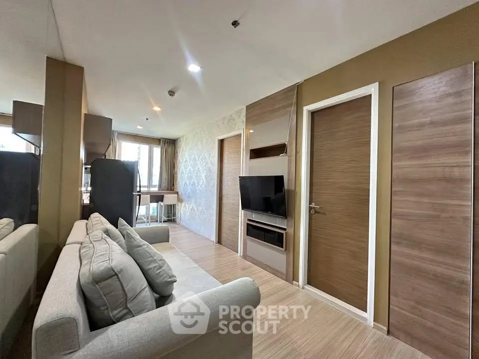 Modern living room with stylish decor and built-in TV unit in a cozy apartment.