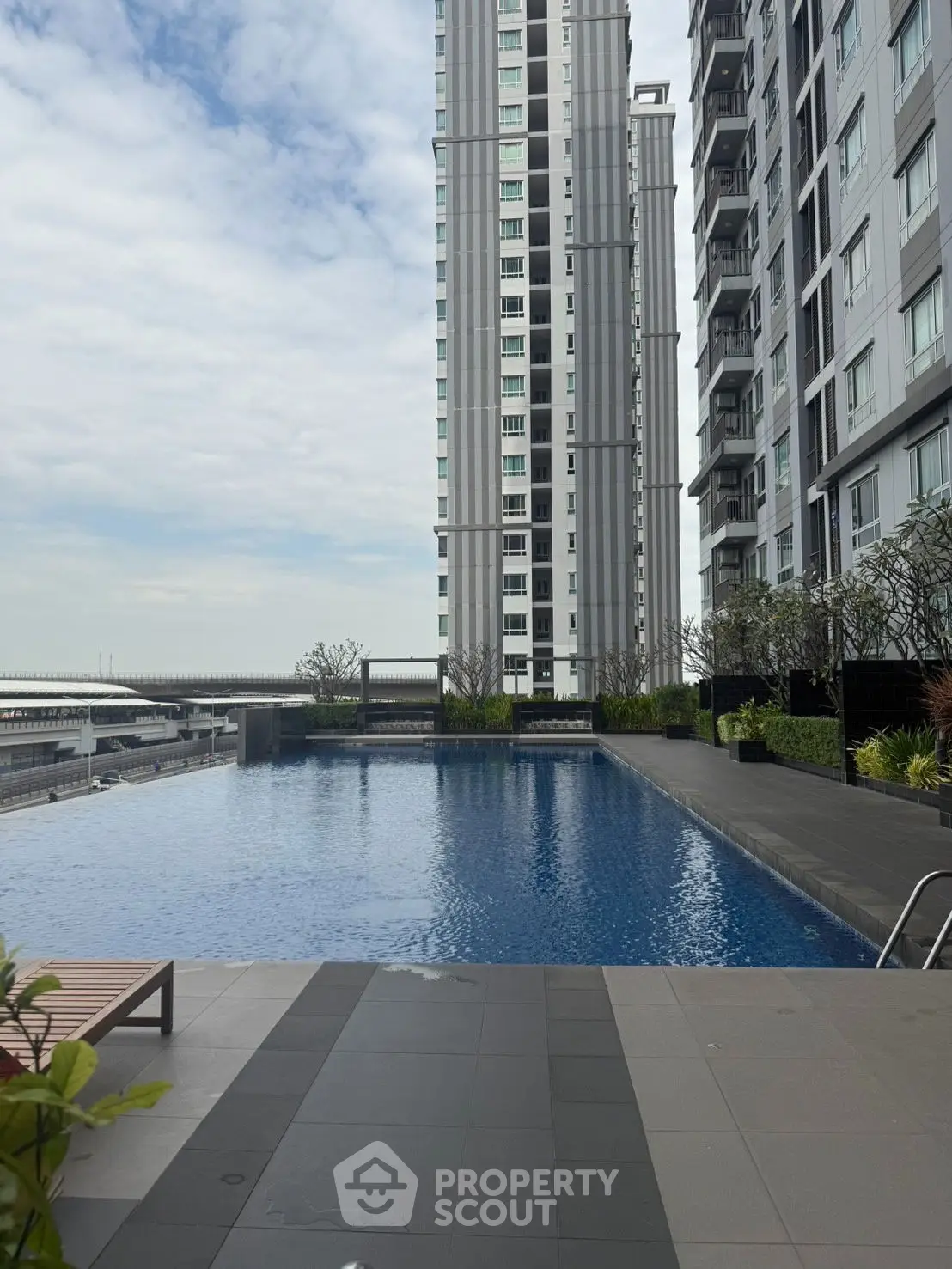 Luxurious high-rise building with stunning pool and city views, perfect for urban living.