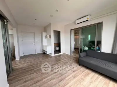 Spacious modern living room with wooden flooring and air conditioning in a contemporary apartment.