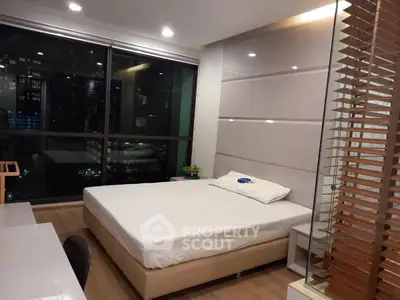 Modern bedroom with large window and city view, featuring sleek design and cozy ambiance.