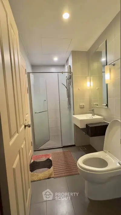 Modern bathroom with glass shower and sleek fixtures in a contemporary home.