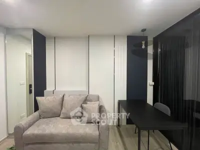Modern living room with stylish sofa and sleek black desk, perfect for urban living.