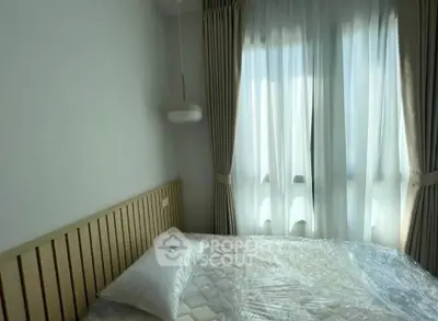 Cozy bedroom with natural light and elegant curtains, perfect for relaxation.