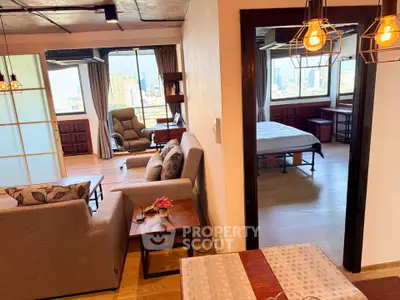 Spacious open-plan living room with city view, modern decor, and cozy bedroom access.