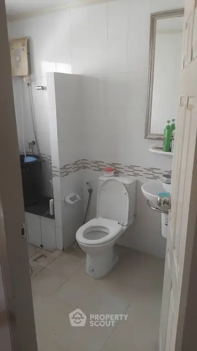 Compact bathroom with modern fixtures and white tile design.