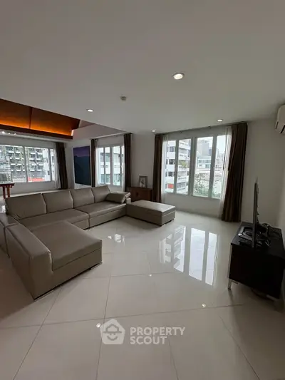 Spacious modern living room with large windows and city view