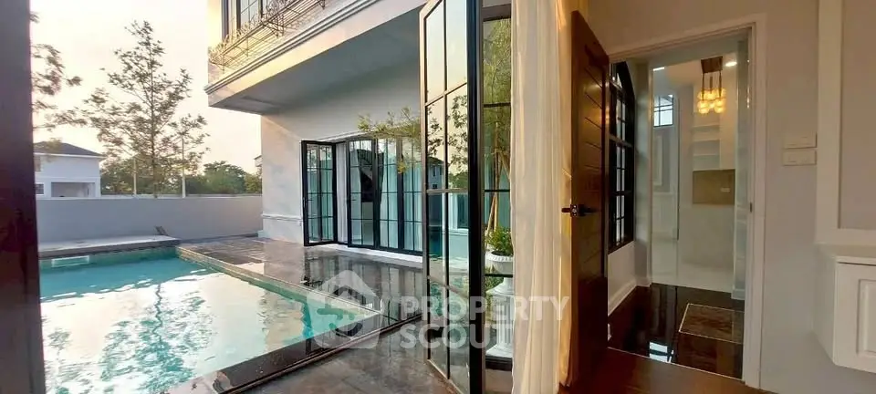 Luxurious modern home with poolside view and elegant glass doors, perfect for serene living.