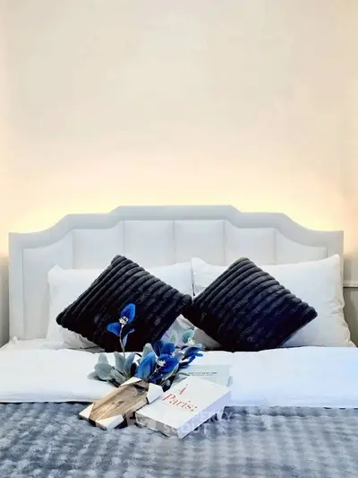 Elegant bedroom with plush pillows and stylish decor, perfect for a cozy retreat.