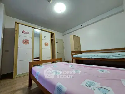 Cozy bedroom with wooden furniture and ample storage space, perfect for a comfortable living experience.