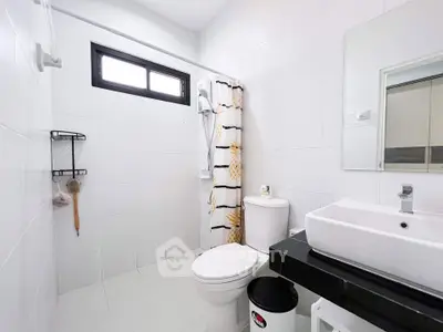 Modern bathroom with sleek white tiles and contemporary fixtures.