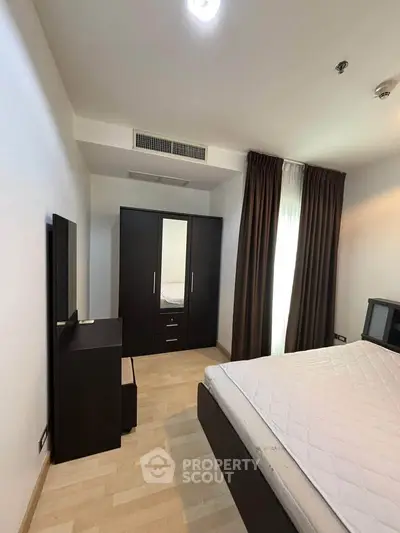 Cozy bedroom with modern furniture and natural light, perfect for restful nights.