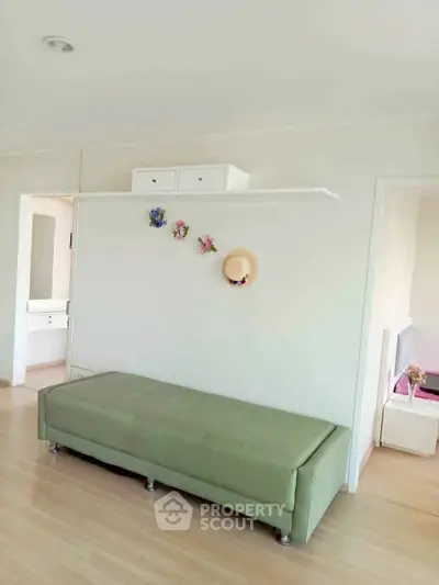 Bright and airy living space with minimalist decor and green sofa, perfect for modern living.