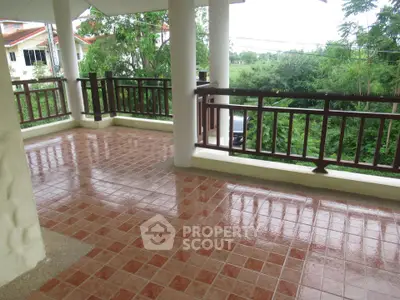 Spacious tiled balcony with lush green views, perfect for relaxation.