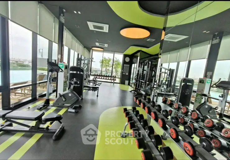 Modern gym with state-of-the-art equipment and large windows offering a bright and airy workout space.